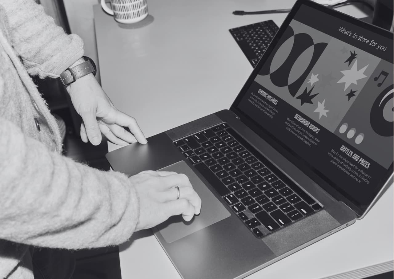 Hands near a laptop in grayscale